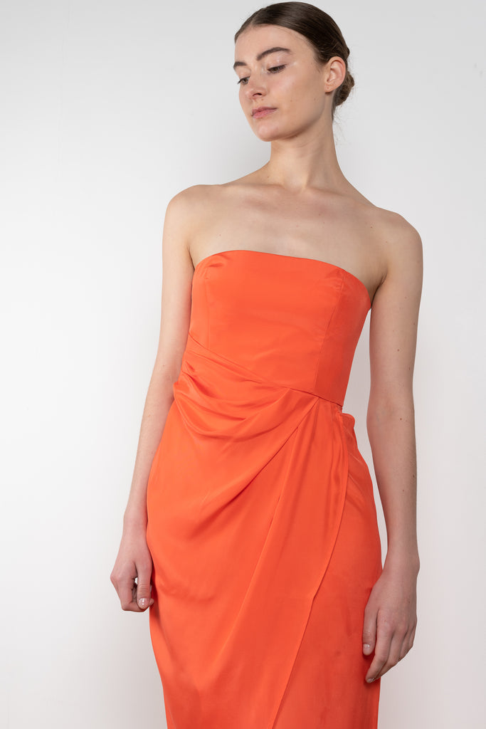 The Lica Long Dress by Gauge81 is a long silk bustier dress with front slit in a vibrant orange linen