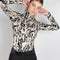 The turtleneck top by Paco Rabanne is a structured jacquard top in a black, gold and cream print