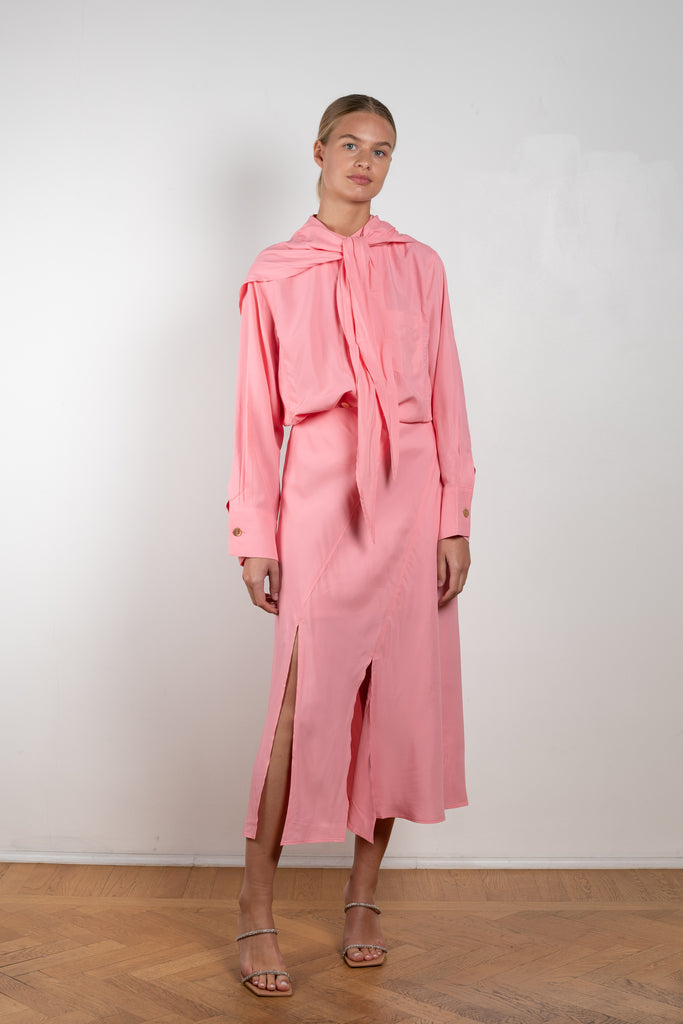 The Remi Skirt by Rejina Pyo is a high waisted midi length skirt with slits and deconstructed panels in a pink fluid viscose