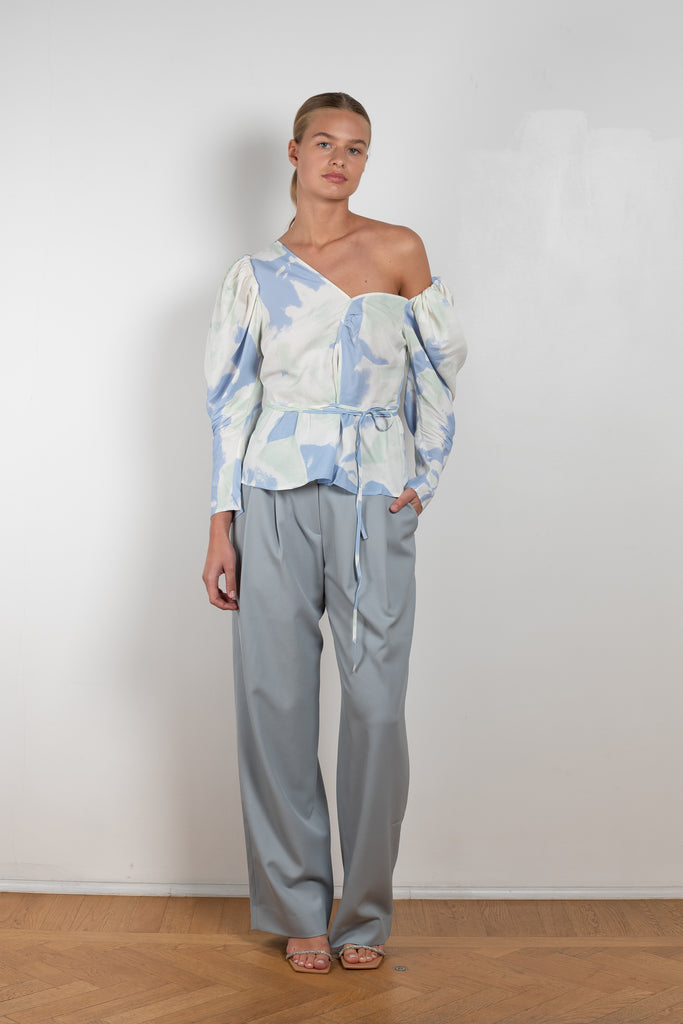 The Fiona Top by Rejina Pyo is a one-shoulder top with long puff sleeves, a tie detail to cinch the waist and exaggerated cuffs