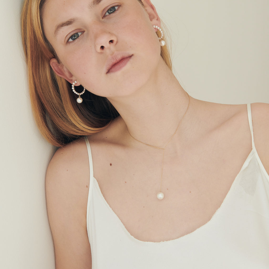 The Boucle Marco Perle Earrings by Sophie Bille Brahe are 14Kt Gold hoop earrings with freshwater pearls descending in size from the front to the back