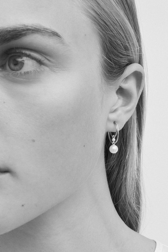 The Petit Bain Earring by Sophie Bille Brahe is a petite single hoop earring with several pearls