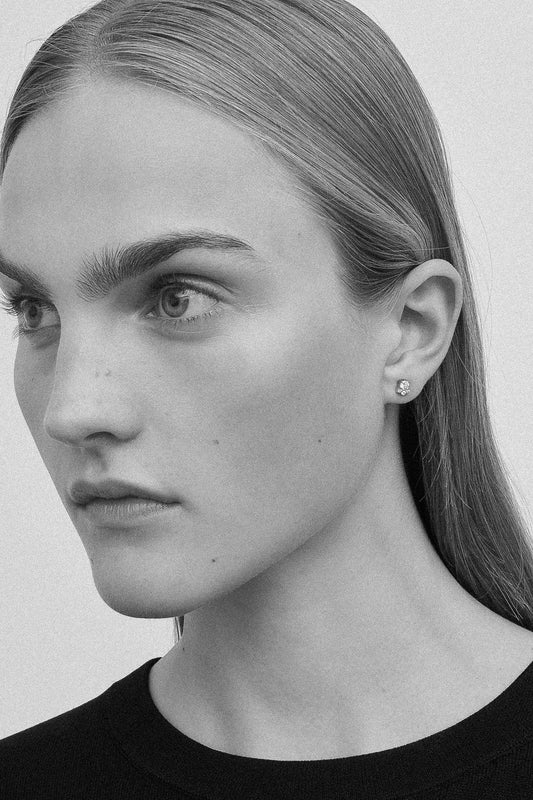 The River Trois Earring by Sophie Bille Brahe is  a delicate and classic single stud earring featuring a diamond solitaire surrounded by three smaller diamonds