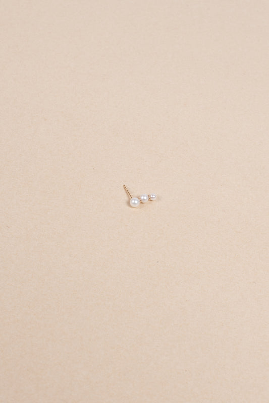 The Trois Perle Earring by Sophie Bille brahe is a delicate earring with pearls graduating in size, handcrafted in 14K yellow gold with freshwater pearls