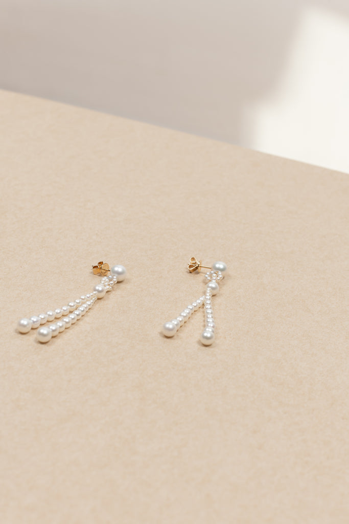 The Opera Earrings by Sophie Bille Brahe are statement drop earrings with white freshwater pearls graduating in size