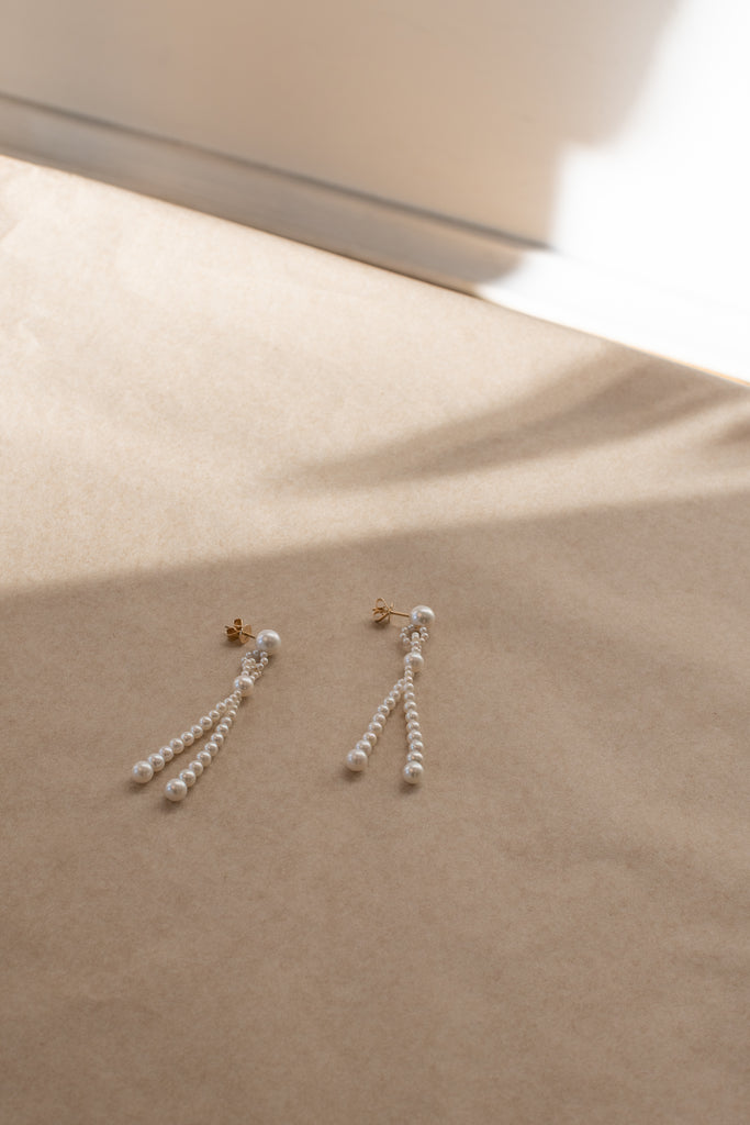 The Opera Earrings by Sophie Bille Brahe are statement drop earrings with white freshwater pearls graduating in size