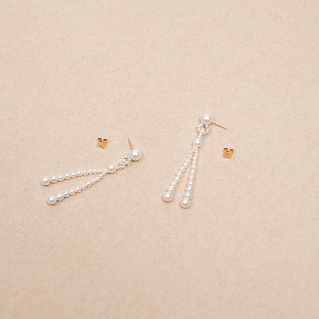 The Opera Earrings by Sophie Bille Brahe are statement drop earrings with white freshwater pearls graduating in size