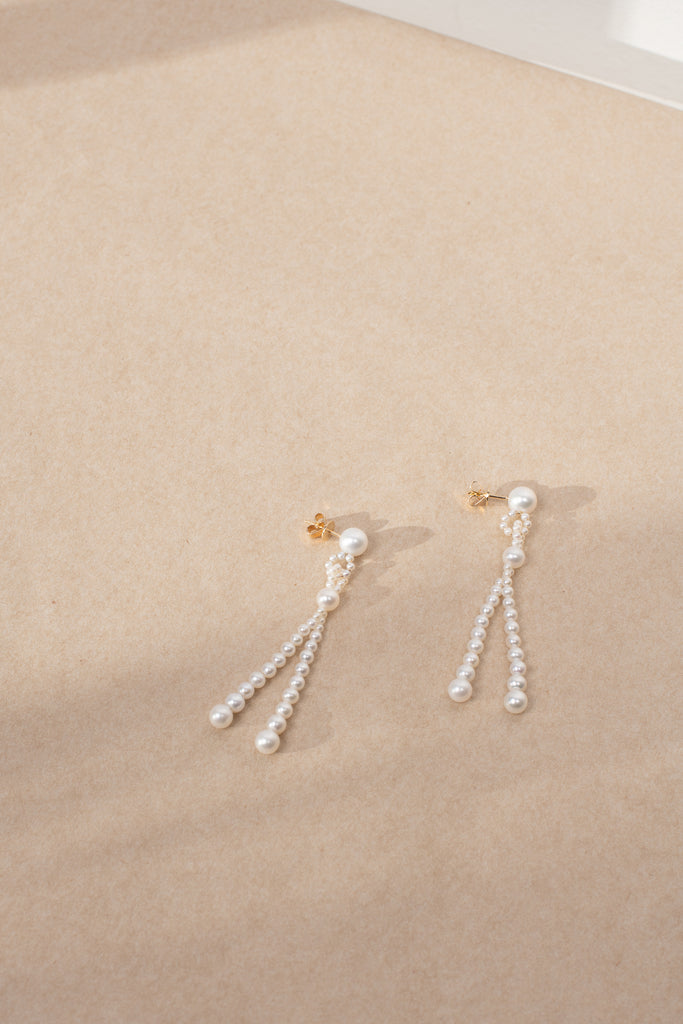 The Opera Earrings by Sophie Bille Brahe are statement drop earrings with white freshwater pearls graduating in size